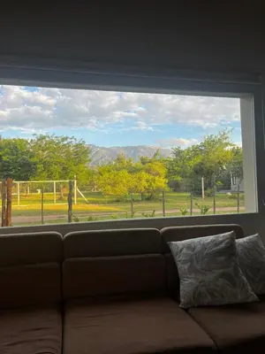 a couch sitting in front of a large window at Altos de la Quebrada in Quebrada de los Pozos