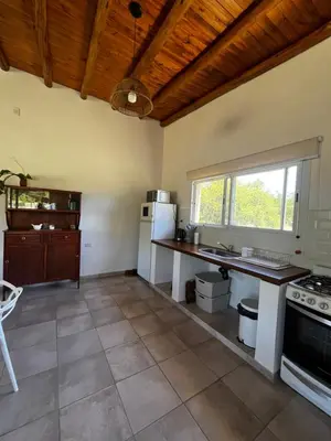 a large kitchen with a counter and a refrigerator at Altos de la Quebrada in Quebrada de los Pozos