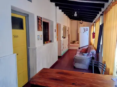 a hallway with a couch and a table in a room at Casona La Ventanita in Mina Clavero