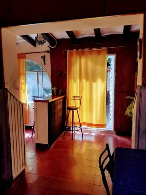 a kitchen with a yellow curtain and a table and chairs at Casona La Ventanita in Mina Clavero