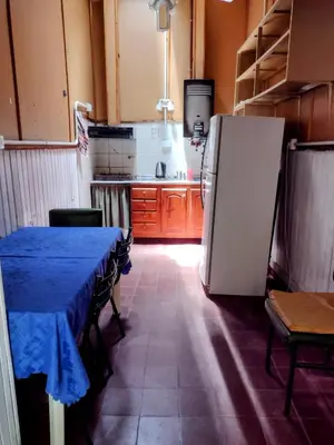 a kitchen with a table and a refrigerator at Casona La Ventanita in Mina Clavero
