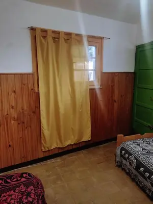 a bedroom with a yellow curtain and a window at Casona La Ventanita in Mina Clavero