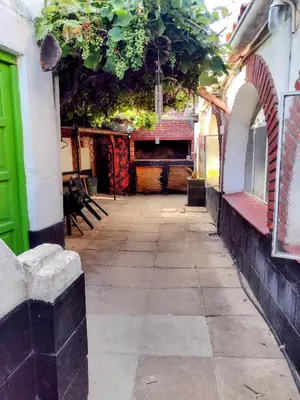 an alley with a green door and a building at Casona La Ventanita in Mina Clavero