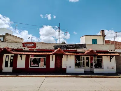 an old red and white building on a street at Casona La Ventanita in Mina Clavero