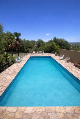 a swimming pool with blue water in a yard at Casa con pileta in Villa Carlos Paz