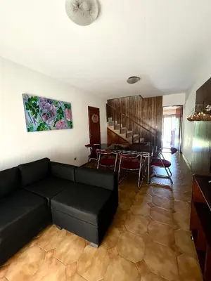 a living room with a black couch and a table at Casa con pileta in Villa Carlos Paz