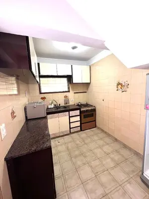 a large kitchen with a sink and a stove at Casa con pileta in Villa Carlos Paz