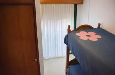 a bedroom with a bed with a flower on it at Casa con pileta in Villa Carlos Paz