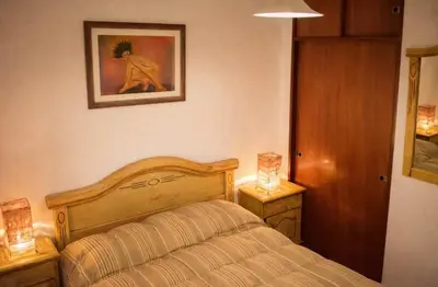 a bedroom with a bed and two lamps on tables at Casa con pileta in Villa Carlos Paz