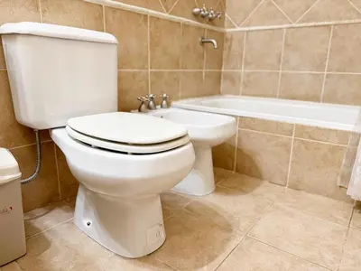 a bathroom with a toilet and a bath tub at Torre Melos Carlos Paz in Villa Carlos Paz