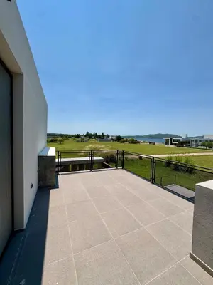 a large patio with a view of a golf course at Duplex con pileta frente a lago Los Molinos in La Estancia