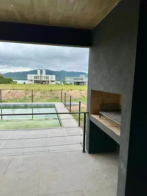 a building with a patio with a view of a field at Duplex con pileta frente a lago Los Molinos in La Estancia