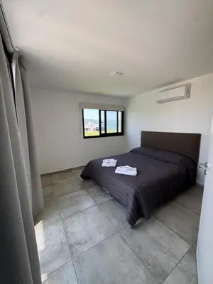 a bedroom with a bed and a window at Duplex con pileta frente a lago Los Molinos in La Estancia