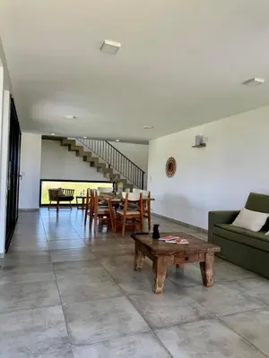 a living room with a couch and a table at Duplex con pileta frente a lago Los Molinos in La Estancia