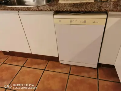 a kitchen with white cabinets and a dishwasher at little house between mountains in Villa Carlos Paz