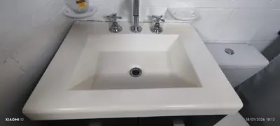 a white sink in a bathroom with a toilet at little house between mountains in Villa Carlos Paz