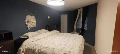 a bedroom with a bed with a white comforter at little house between mountains in Villa Carlos Paz