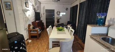 a kitchen and living room with a white table and chairs at little house between mountains in Villa Carlos Paz