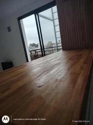 a wooden table in a room with a large window at Carmen alojamientos in Cordoba