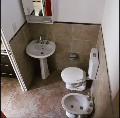 a small bathroom with a toilet and a sink at Urquiza 1 in Pilar