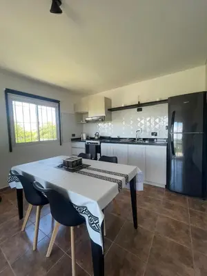 a kitchen with a table and chairs and a refrigerator at Bella Vista in Villa Carlos Paz