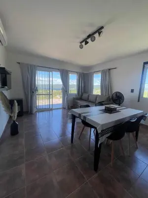 a living room with a table and a couch at Bella Vista in Villa Carlos Paz