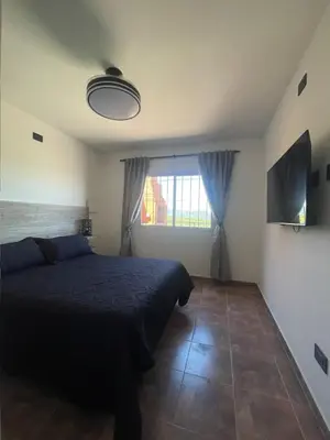 a bedroom with a bed and a large window at Bella Vista in Villa Carlos Paz