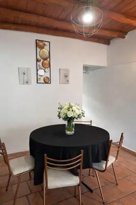 a vase of flowers on a table with chairs at Fuego in Nono