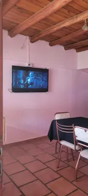 a tv on a wall in a room with a chair at Fuego in Nono