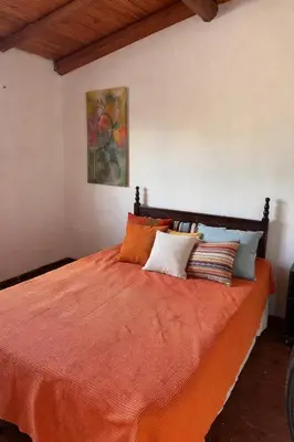 a bedroom with an orange bed with pillows on it at Fuego in Nono