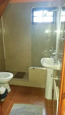 a bathroom with a toilet and a sink and a shower at Cabañas atardecer soñado in Villa Yacanto