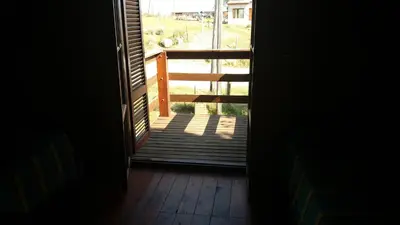 an open door to a porch with a view of a deck at Cabañas atardecer soñado in Villa Yacanto