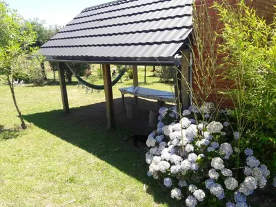 a gazebo with a bench in a garden at Cabañas atardecer soñado in Villa Yacanto