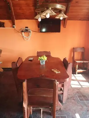 a dining room with a wooden table and chairs at Cabañas atardecer soñado in Villa Yacanto