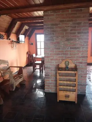 a living room with a brick wall and a table at Cabañas atardecer soñado in Villa Yacanto