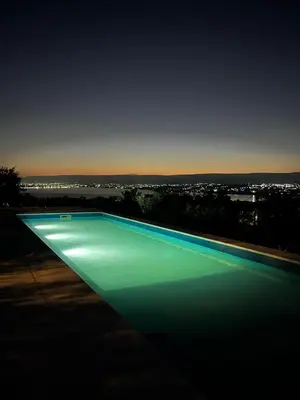 a large swimming pool with green lighting at night at Complejo DOS LUNAS in La Porteña