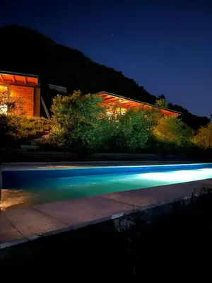 a swimming pool in front of a building at night at Complejo DOS LUNAS in La Porteña