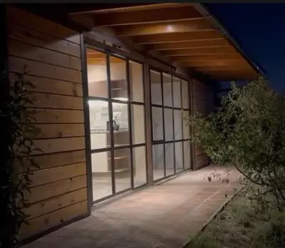 a building with a large glass door on the side at Complejo DOS LUNAS in La Porteña