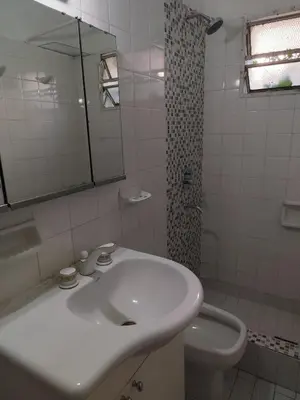 a white bathroom with a sink and a toilet at Casa con pileta y jardín - 3 dormitorios in Villa Carlos Paz