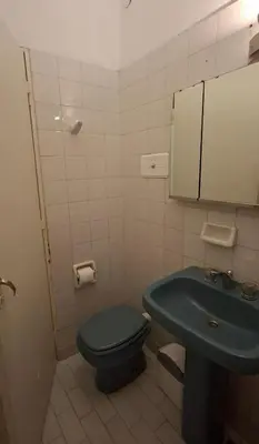 a bathroom with a blue toilet and a sink at Casa con pileta y jardín - 3 dormitorios in Villa Carlos Paz