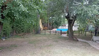 a fence with a blue pool in a yard at Casa con pileta y jardín - 3 dormitorios in Villa Carlos Paz