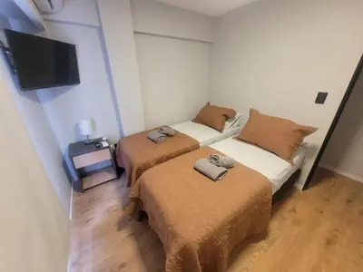 two beds in a small room with a tv at Departamento RONDEAU, NUEVA CÓRDOBA in Cordoba