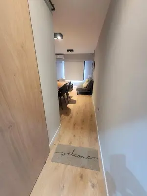 a hallway with a table and a door with a welcome mat at Departamento RONDEAU, NUEVA CÓRDOBA in Cordoba