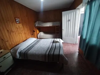 a small bedroom with a bed and a window at Nuevo Chalet Suizo in Villa Carlos Paz