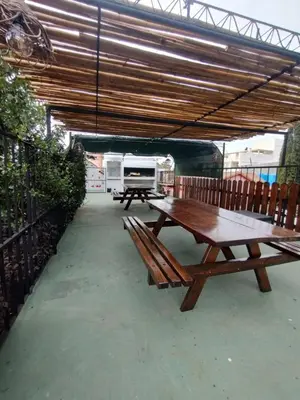 a picnic table and benches under a roof at Nuevo Chalet Suizo in Villa Carlos Paz