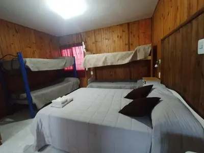 a bedroom with a large bed and a couch at Nuevo Chalet Suizo in Villa Carlos Paz