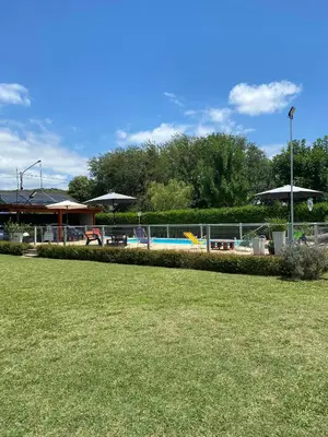 a park with a swimming pool and umbrellas at LA TORRE - Complejo de cabañas in Villa Rumipal