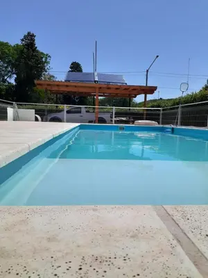 a large blue swimming pool with a gazebo at LA TORRE - Complejo de cabañas in Villa Rumipal