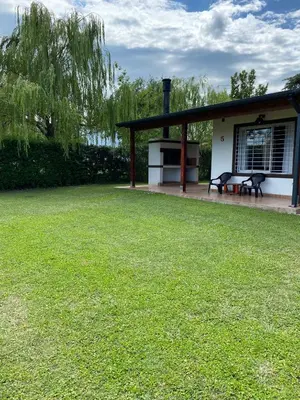 a picnic shelter with a bench in a yard at LA TORRE - Complejo de cabañas in Villa Rumipal