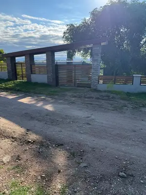 a house with a gate and a fence at Hermosa Casa en Mirador del Lago - Bialet Masse in Bialet Massé